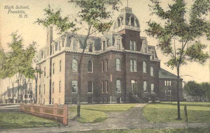 A colored postcard of the old Franklin, New Hampshire high school, a Second Empire brick building with a mansard roof and a small central bell tower, set behind a white-painted fence.