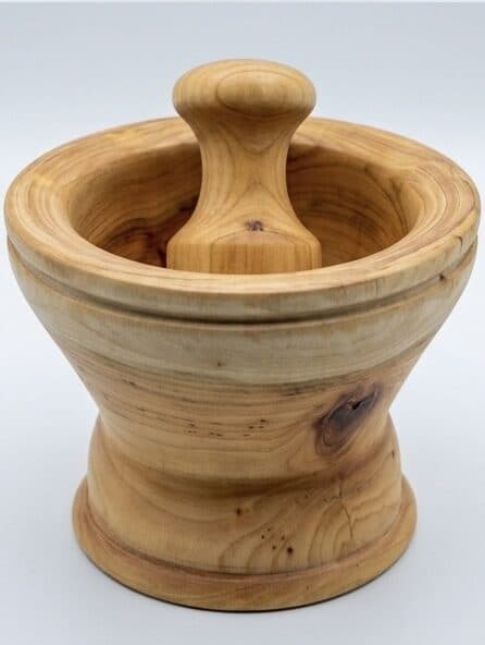 A mortar and pestle in light hardwood, turned to feel familiar in the hand.